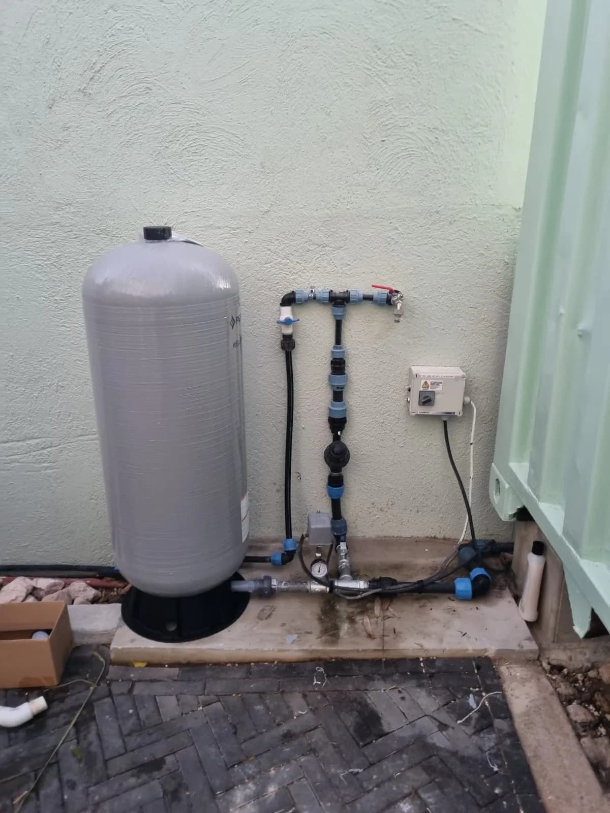 Tanque de presión de agua nuevo con tubería reorganizada de forma ordenada después de la instalación